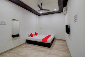a bedroom with a bed with red pillows and a ceiling fan at OYO Flagship Hotel Galaxy in Nagpur