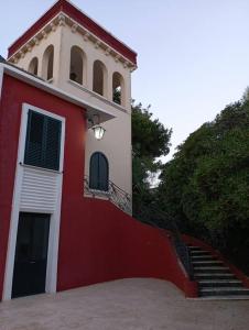 - un bâtiment rouge et blanc avec un escalier à côté dans l'établissement Villa Muia-Appartamento con giardino, à Parabita