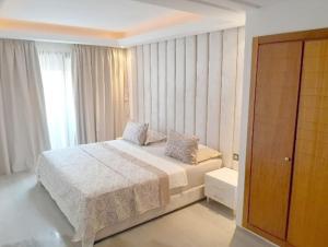 um quarto com uma cama e uma grande janela em La petite charmante em Marrakech