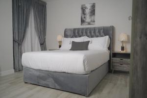 a bedroom with a large bed with a gray headboard at قمة نجد للشقق الفندقيه in Al Khobar