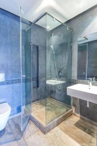 uma casa de banho com um chuveiro, um WC e um lavatório. em La petite charmante em Marrakech