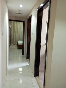 a hallway with a mirror and a room with a bed at Marbella Holiday Homes - Al Nahda 1BHK in Dubai