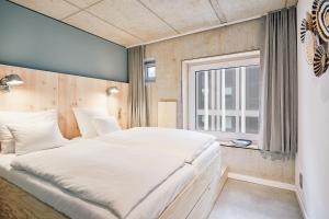 a bedroom with a large bed and a window at Villa Viva - ein Haus das Brunnen baut in Hamburg