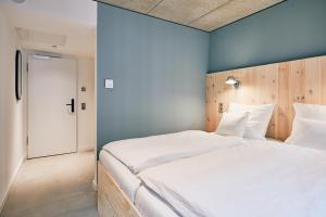 a bedroom with a large bed with a blue wall at Villa Viva - ein Haus das Brunnen baut in Hamburg