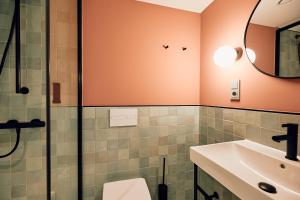 a bathroom with a sink and a shower at Villa Viva - ein Haus das Brunnen baut in Hamburg