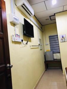 a room with a hospital room with a tv on the wall at Lagenda Resthouse Langkawi in Pantai Cenang