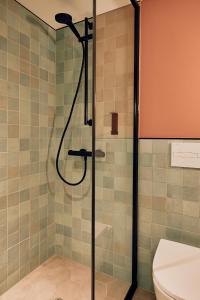 a bathroom with a shower with a glass door at Villa Viva - ein Haus das Brunnen baut in Hamburg