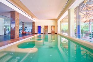 a swimming pool in a large room with a large window at Capanes de Golf Luxury Apt in Benahavís