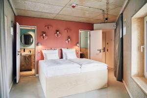 a bedroom with a large white bed and a red wall at Villa Viva - ein Haus das Brunnen baut in Hamburg
