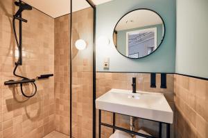 a bathroom with a sink and a mirror at Villa Viva - ein Haus das Brunnen baut in Hamburg