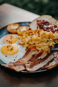 um prato de pequeno-almoço com ovos, bacon e torradas em Bulul Garden Resort em El Nido