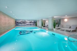 duży basen z niebieską wodą w pokoju hotelowym w obiekcie Ferienwohnungen Strandgrün w mieście Timmendorfer Strand