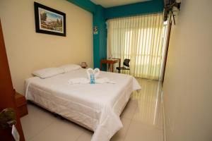 een slaapkamer met een bed met handdoeken erop bij Hotel Suisui in Tarapoto