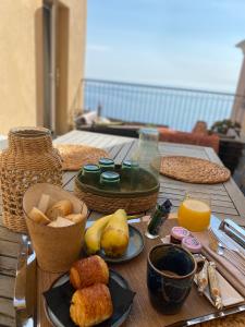 uma mesa de madeira com comida e sumo de laranja em Hôtel Des Gouverneurs em Bastia