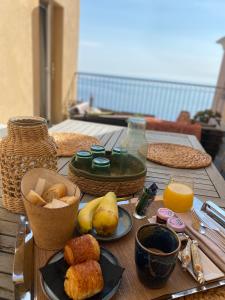 a wooden table topped with food and orange juice at Hôtel Des Gouverneurs in Bastia