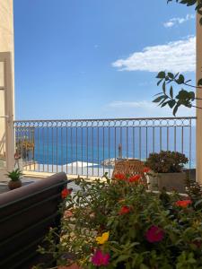 a view of the ocean from a balcony with flowers at Hôtel Des Gouverneurs in Bastia