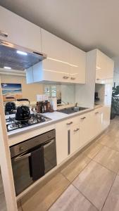 a kitchen with white cabinets and a stove top oven at Tanelsa Apartment on West in Johannesburg