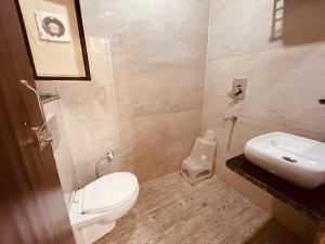 a bathroom with a white toilet and a sink at The Divine Ganga - Top Rated and Most Awarded Property In Haridwar in Haridwār