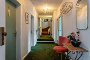 un couloir avec des escaliers, une table et des chaises dans l'établissement Pension Landhaus, à Brombachtal