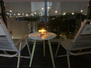 a table and two chairs on a balcony with a candle at Jome Putrajaya Presint 8 Natural Homestay in Putrajaya