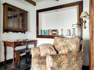 um quarto com uma cadeira, uma mesa e um espelho em Calhau Grande em Arco da Calheta