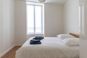 een slaapkamer met een bed met twee handdoeken erop bij Joli T2 Champagne au Mont d'or in Saint-Didier-au-Mont-dʼOr