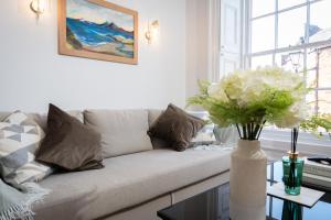 a living room with a couch and a vase of flowers at Bridge View in Annan