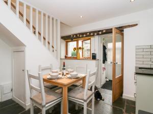 a kitchen and dining room with a table and chairs at Jessie's Cottage in Kendal