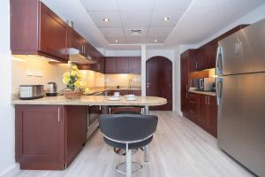 a kitchen with wooden cabinets and a table and a refrigerator at OFFER-Book 4BR Villa and Ride at Luxury Yacht FREE in Dubai