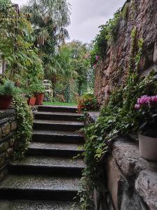 un conjunto de escaleras de piedra con flores y plantas en Casa Lumaca en Tremezzo