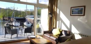 a living room with a couch and a large window at Marina Boathouse, lake windermere lets in Bowness-on-Windermere