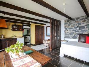 ein Wohnzimmer mit einem Bett und eine Küche in der Unterkunft Calhau Grande in Arco da Calheta