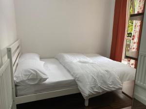 a white bed with white sheets and pillows on it at Two Bedroom apartment with river view in London