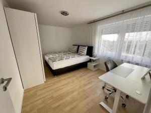 1 dormitorio con cama, escritorio y mesa en Apartment Dußlingen, 