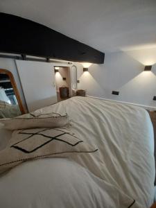 um quarto com uma grande cama branca e 2 almofadas em REFUGE - Bel appartement au Panier et vue mer em Marselha