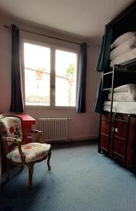 una camera da letto con una sedia, un letto e una finestra di Hostel Toulouse Wilson a Tolosa