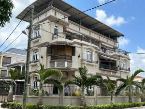 a white building with palm trees in front of it at Apartment Huz Peer 1 in Triolet