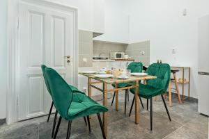 comedor con mesa y sillas verdes en Royal 5* mansion near central square en Cluj-Napoca