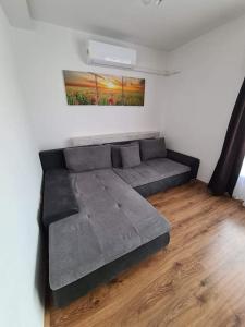 a large bed in a room with a wooden floor at SmartHomeApartman in Hajdúszoboszló