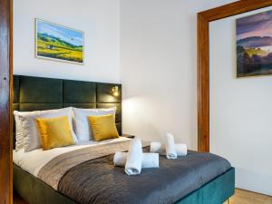 una camera da letto con un grande letto con cuscini gialli di Tyzenhauz Apartments Old Town a Cracovia