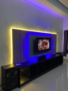 a living room with a tv and blue lighting at Pondok Kaja Kauh in Bangli