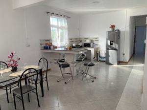 蒙舒瓦西的住宿－Palm Creek Villa，厨房配有桌椅和冰箱。