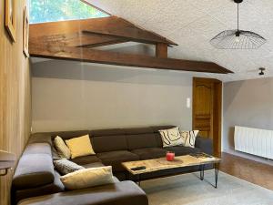 a living room with a brown couch and a table at Maison chaleureuse - Gérardmer in Gérardmer