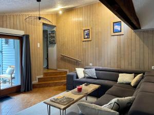 a living room with a couch and a table at Maison chaleureuse - Gérardmer in Gérardmer