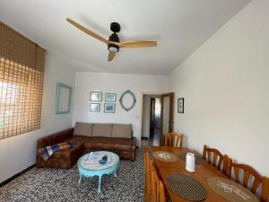 a living room with a couch and a ceiling fan at Amplio apartamento junto al mar in Calabardina