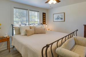 een slaapkamer met een bed, een stoel en ramen bij Idyllic Country Cottage about 18 Mi to Lake Bridgeport in Decatur