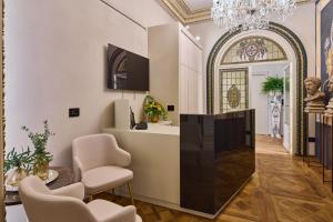 a living room with a chandelier and a hallway with chairs at Duomo Luxury Florence in Florence