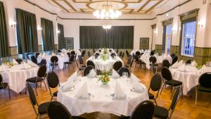un salón de banquetes con mesas y sillas con manteles blancos en Hotel Harmonien en Nakskov