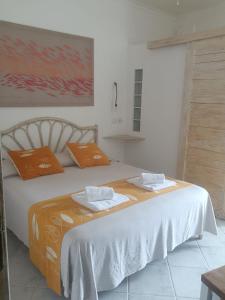 ein Schlafzimmer mit einem großen Bett mit orangefarbenen Kissen in der Unterkunft Piccolo Hotel Luisa in Ponza