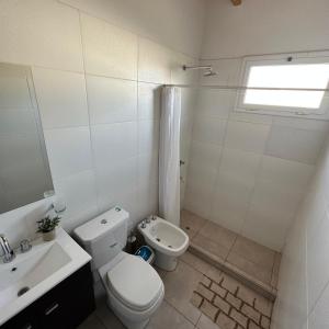 a white bathroom with a toilet and a sink at Espectacular departamento a estrenar en Mendoza in Godoy Cruz